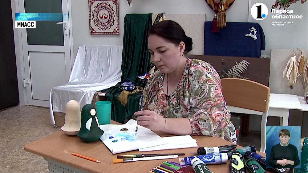 Мастерица вручную расписывает матрешек