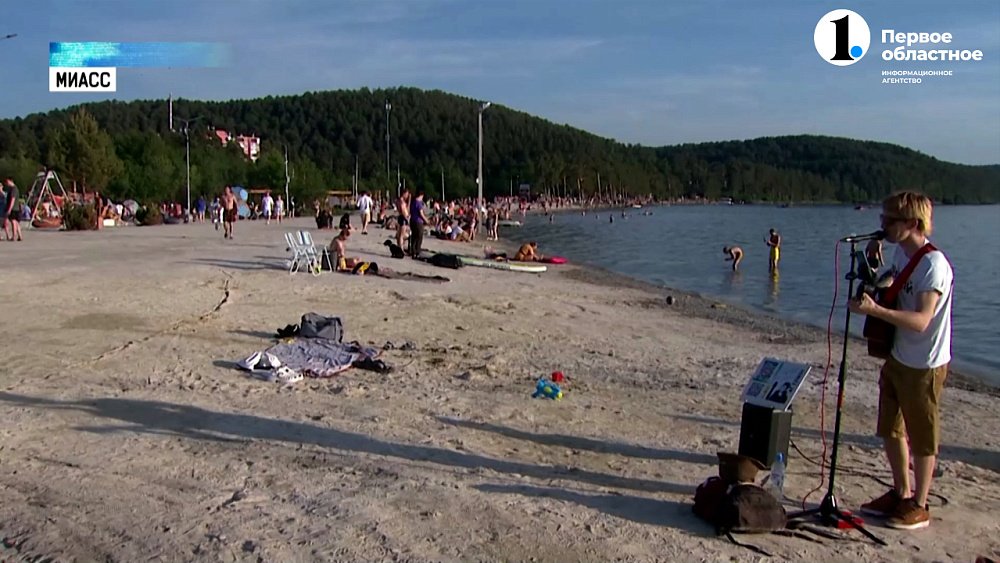 Уличный музыкант играет на берегу Тургояка