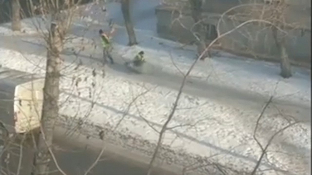 Коммунальщики посыпают дорожки с помощью санок