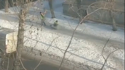 Коммунальщики посыпают дорожки с помощью санок