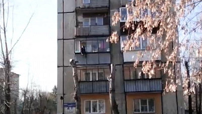 Мужчина, свисающий с балкона третьего этажа, попал на видео