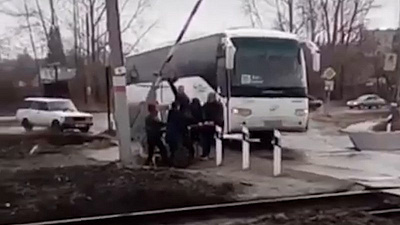 Заполненный пассажирский автобус застрял на железнодорожном переезде