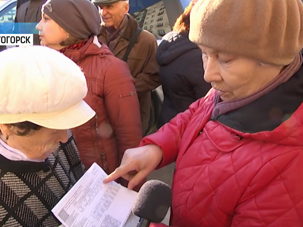 человек оплачивает счета. платежка жкх. долги по жкх. счета за коммуналку. человек с квитанцией жкх.