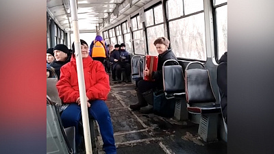 Дедушка в трамвае играет на баяне для пассажиров